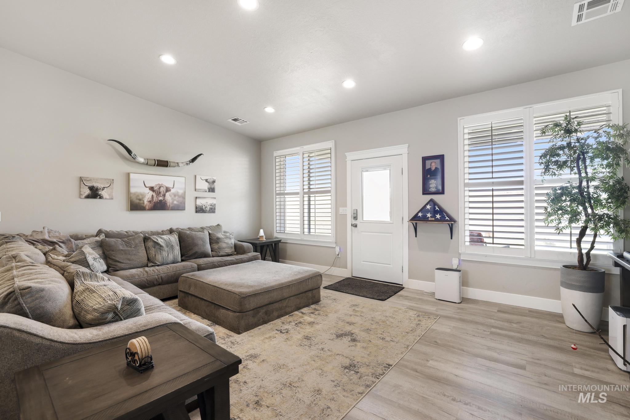 758 Cedar Crk Road Rogerson, ID 83302 - Photo 5 of 50 Bright living space featuring recessed lighting, multiple windows with blinds, a white paneled door, and light wood-finish flooring