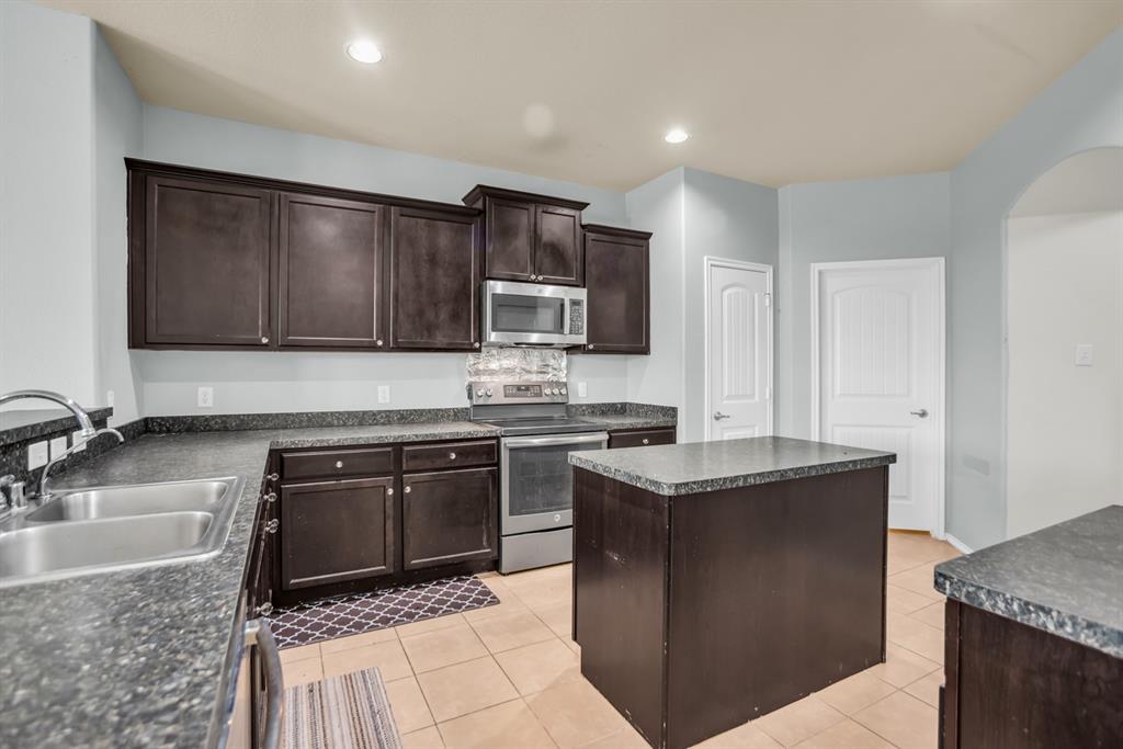 2114 Cedar Trail Anna, TX 75409 - Photo 15 of 34 a kitchen with stainless steel appliances granite countertop a sink stove and microwave