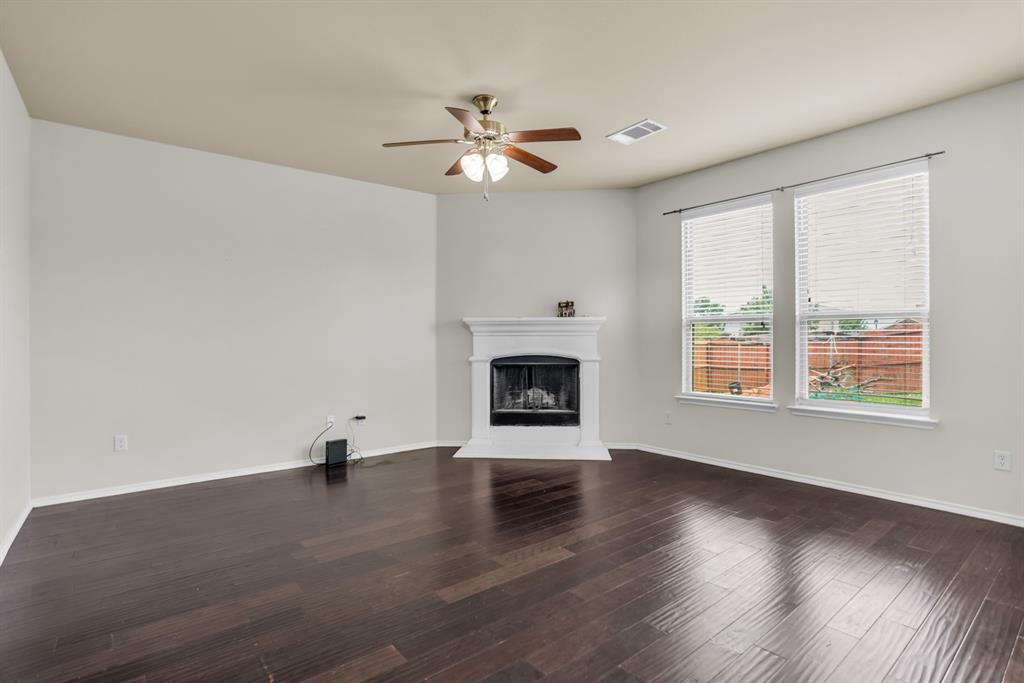 2114 Cedar Trail Anna, TX 75409 - Photo 8 of 34 a view of an empty room with wooden floor fireplace and a window