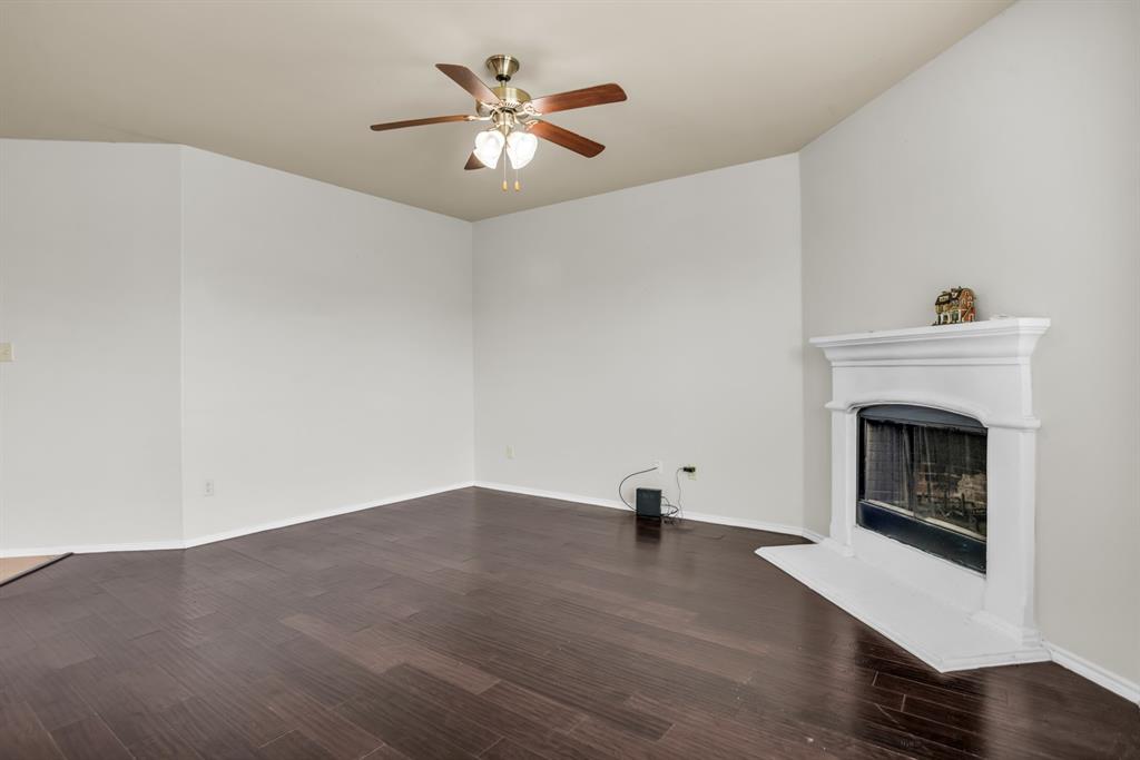 2114 Cedar Trail Anna, TX 75409 - Photo 9 of 34 an empty room with a fireplace and wooden floor