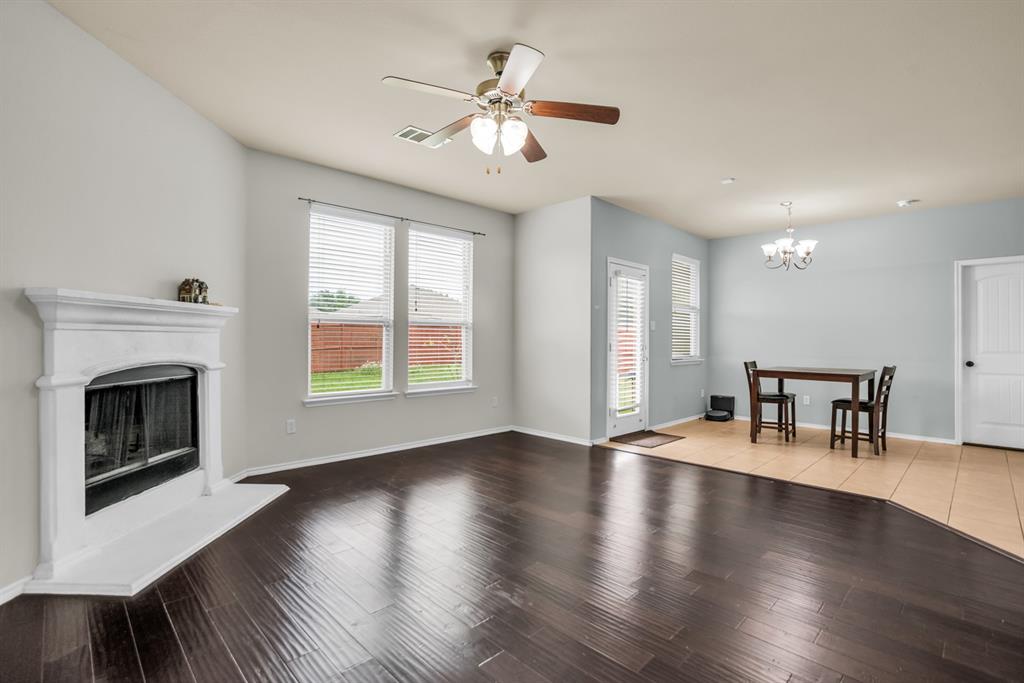 2114 Cedar Trail Anna, TX 75409 - Photo 10 of 34 a view of a livingroom with furniture a fireplace wooden floor and a chandelier