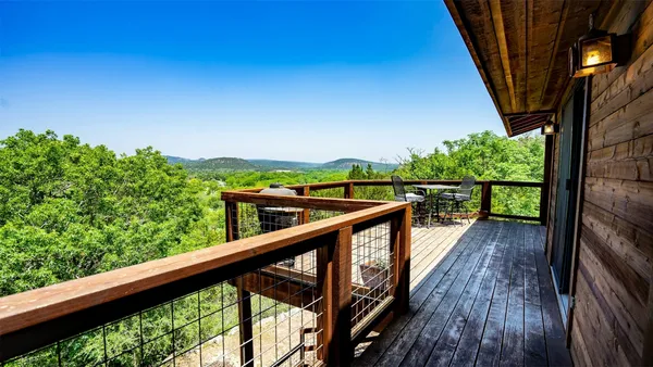 a view of a balcony with wooden floor and fence