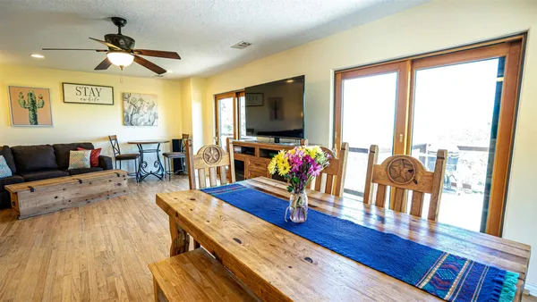 a view of a dining room with furniture a chandelier and wooden floor
