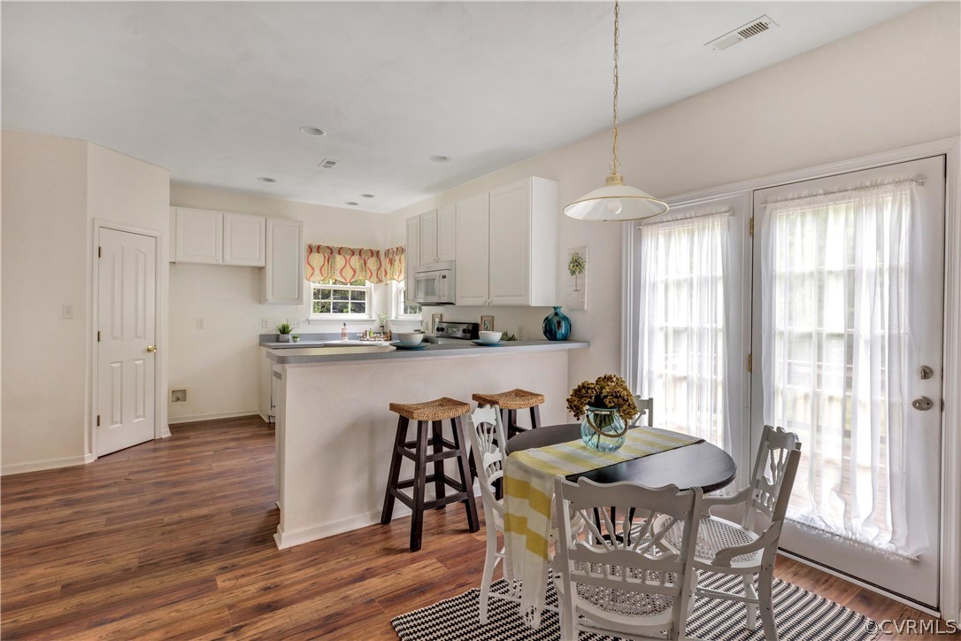 19907 Ivan Road Petersburg, VA 23803 - Photo 3 of 26 a kitchen with stainless steel appliances granite countertop a stove a refrigerator a kitchen island a table and chairs with wooden floor