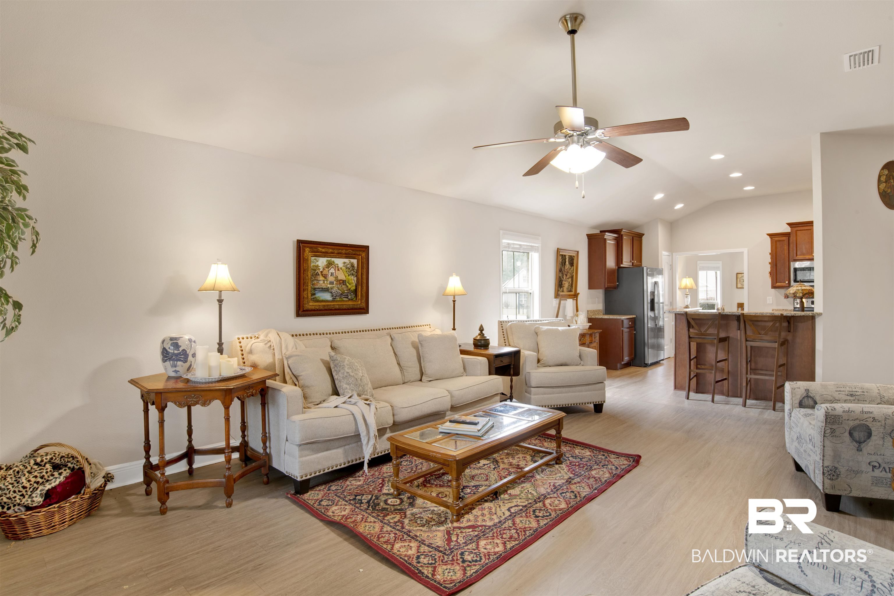 22056 Garland Loop Silverhill, AL 36576 - Photo 9 of 28 Living area featuring visible vents, light wood-style floors, ceiling fan, and vaulted ceiling