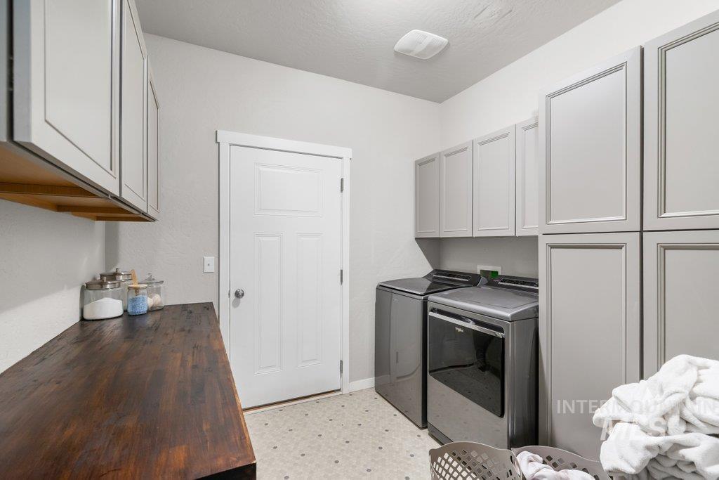 6697 West Irish Circle Rathdrum, ID 83858 - Photo 18 of 36 Laundry room featuring light floors, cabinet space, and washer and clothes dryer