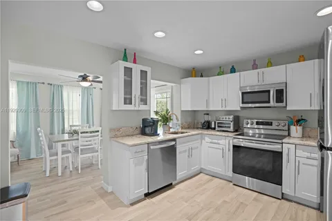 a kitchen with white cabinets stainless steel appliances and sink