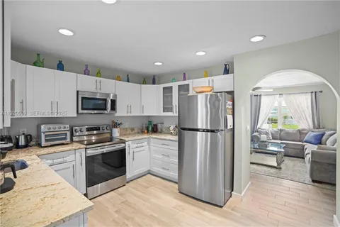 a kitchen with stainless steel appliances granite countertop a refrigerator stove microwave and sink
