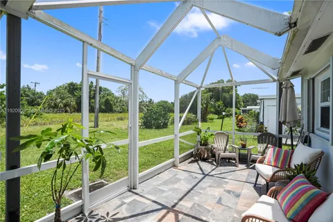 a view of a patio with table and chairs under an umbrella