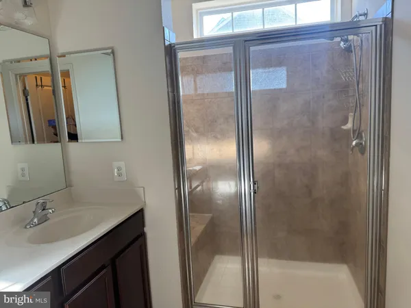a bathroom with a shower sink and mirror
