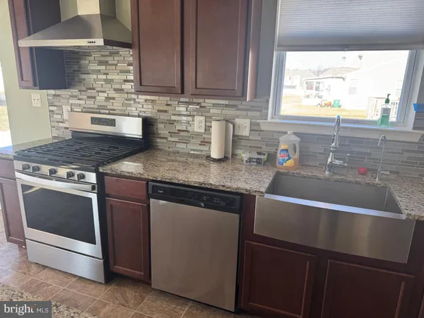 a kitchen with stainless steel appliances granite countertop a sink stove and cabinets