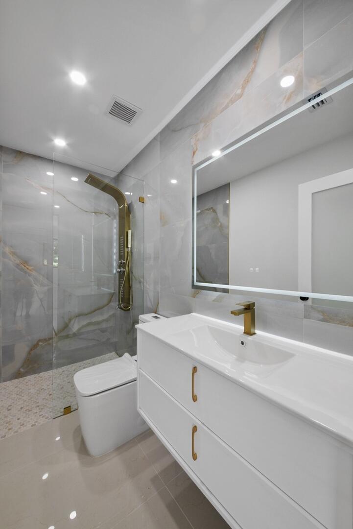 860 Northwest 70th Street Miami, FL 33150 - Photo 12 of 25 a bathroom with a double vanity sink toilet and a mirror
