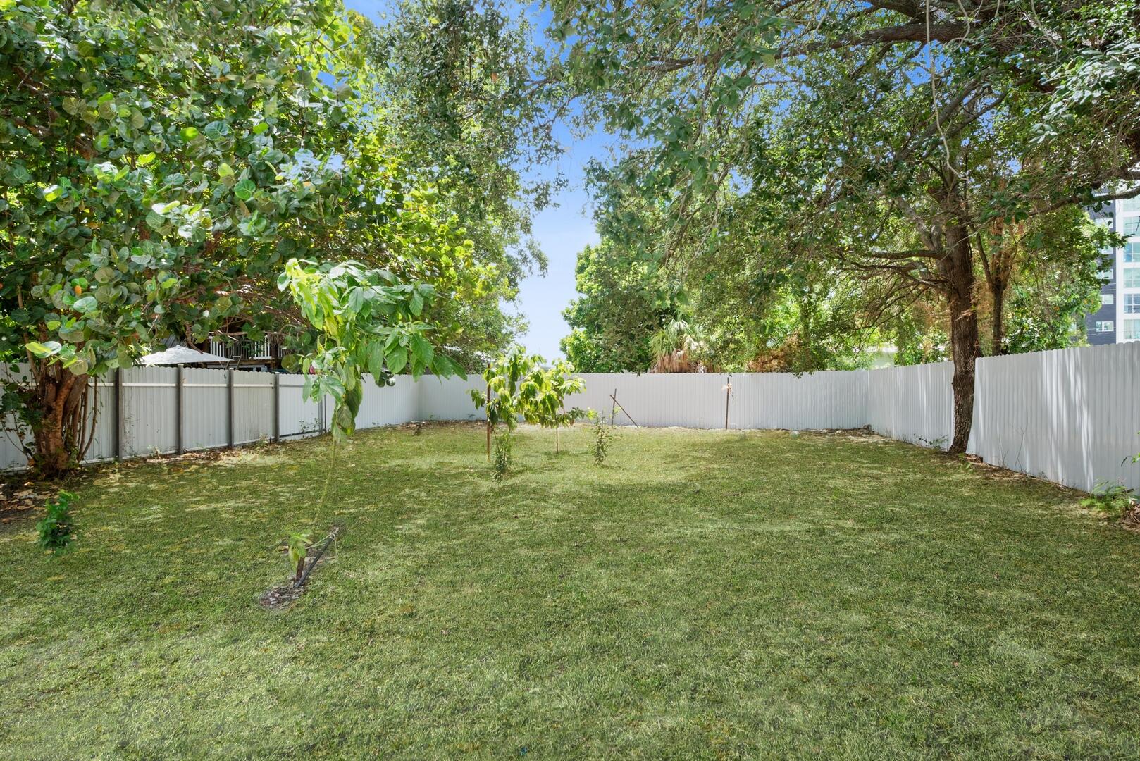 860 Northwest 70th Street Miami, FL 33150 - Photo 18 of 25 a backyard of a house with a barn and large trees