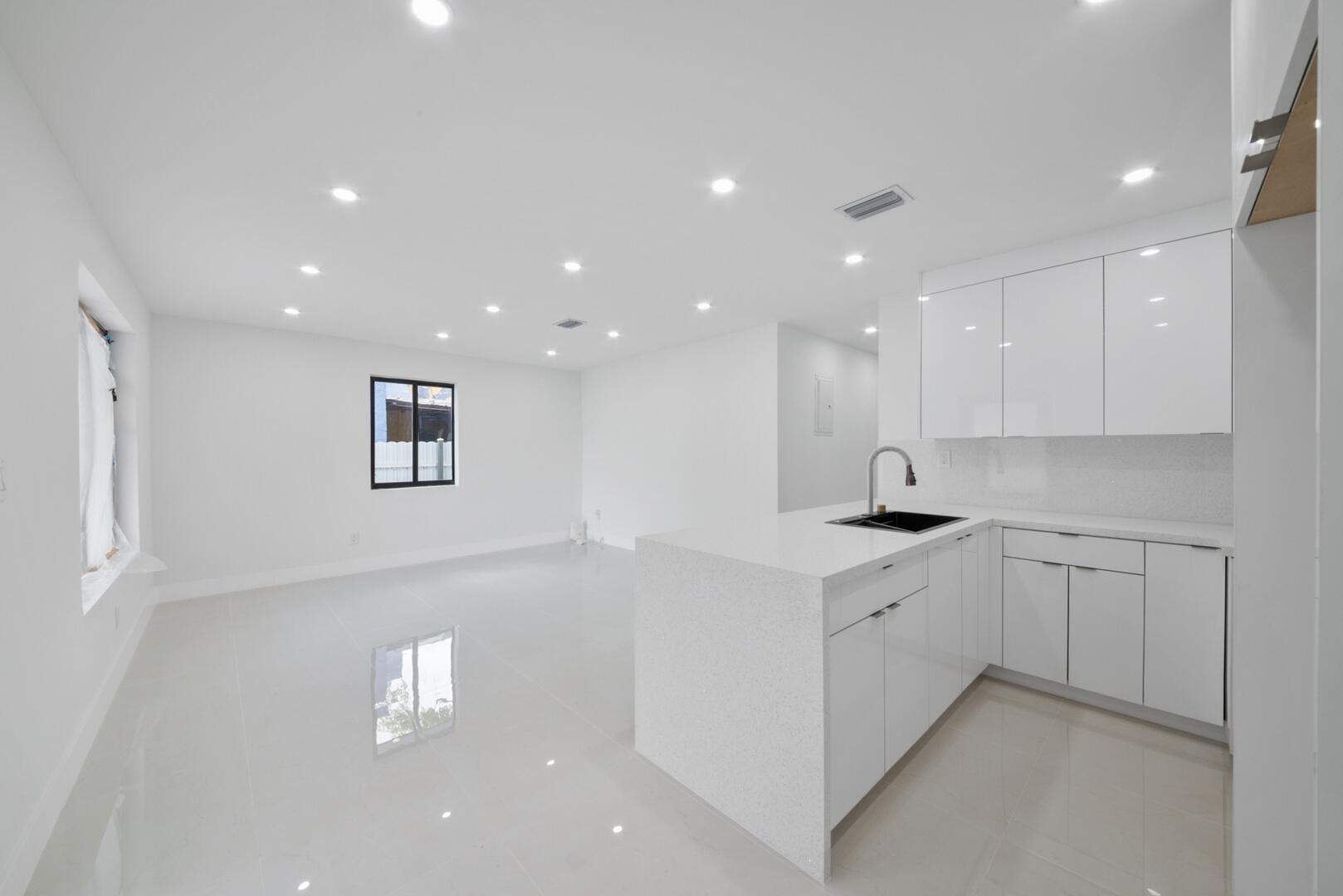 860 Northwest 70th Street Miami, FL 33150 - Photo 5 of 25 a kitchen with white cabinets appliances and a sink