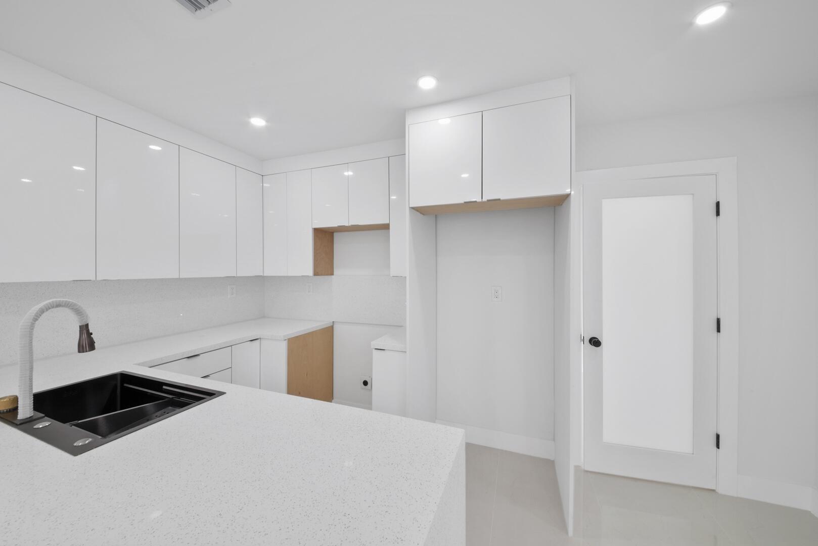 860 Northwest 70th Street Miami, FL 33150 - Photo 6 of 25 a kitchen with a refrigerator and white cabinets
