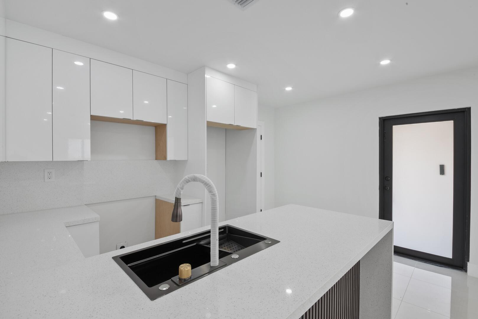 860 Northwest 70th Street Miami, FL 33150 - Photo 8 of 25 a kitchen with a sink a stove and refrigerator