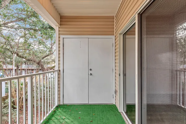 a view of a porch with a door and wooden floor