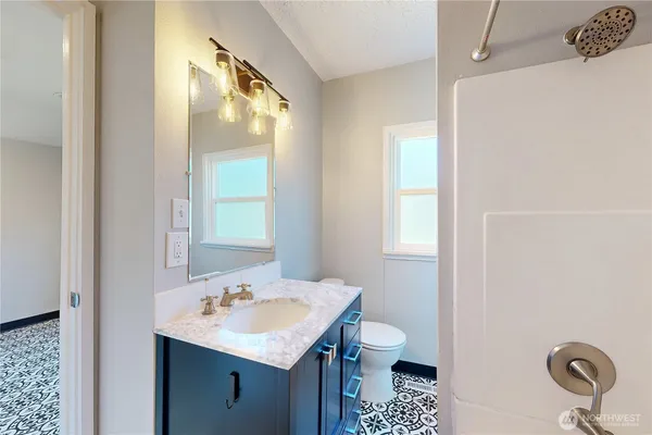 a bathroom with a sink a toilet and a window