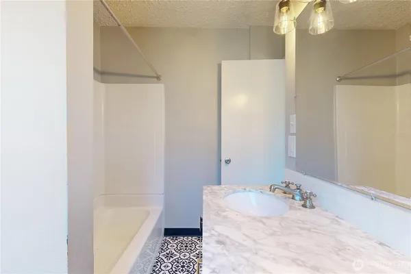 a bathroom with a tub sink and vanity