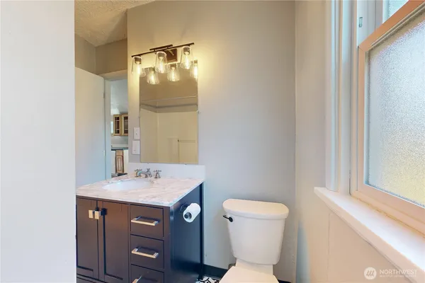 a bathroom with a sink vanity mirror and toilet