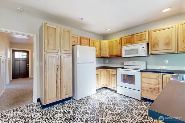 a kitchen with stainless steel appliances granite countertop a refrigerator sink and stove