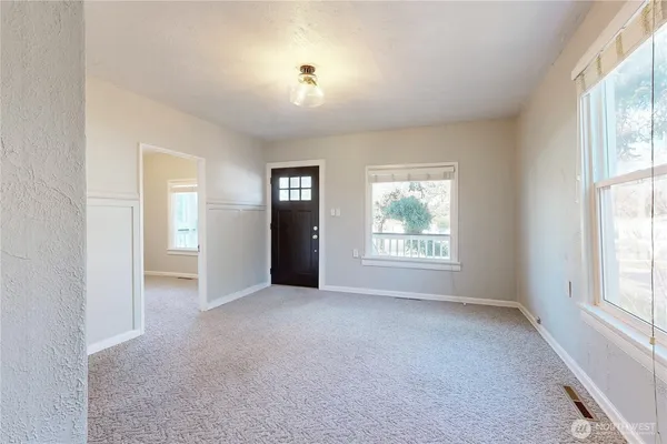 an empty room with windows and closet