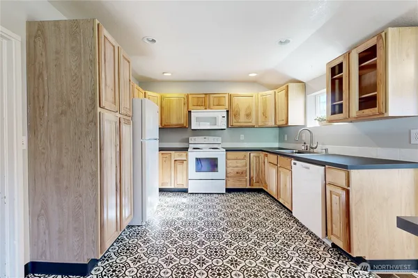 a kitchen with stainless steel appliances granite countertop a refrigerator and a stove top oven
