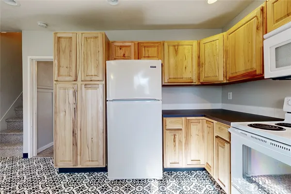 a kitchen with a refrigerator a stove and cabinets