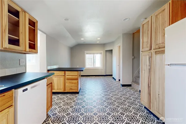 a view of a refrigerator in kitchen and utility room