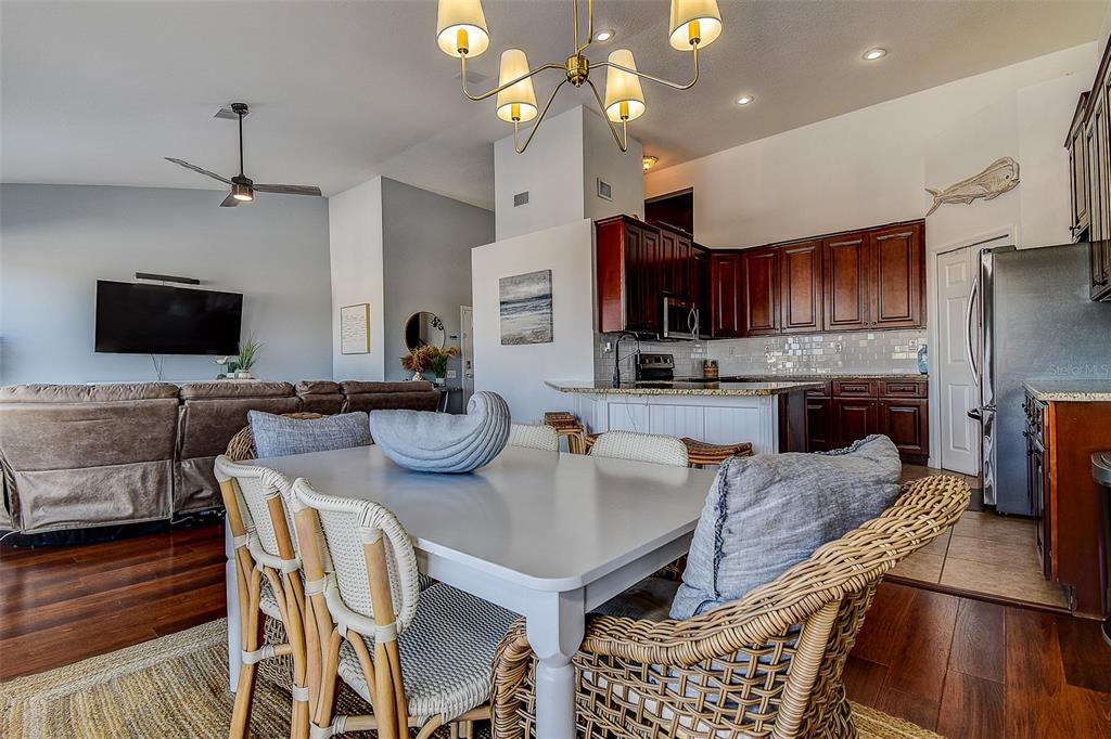 5309 Boardwalk Street Holiday, FL 34690 - Photo 12 of 50 a kitchen with granite countertop kitchen island stainless steel appliances a stove a sink a microwave a refrigerator and cabinets