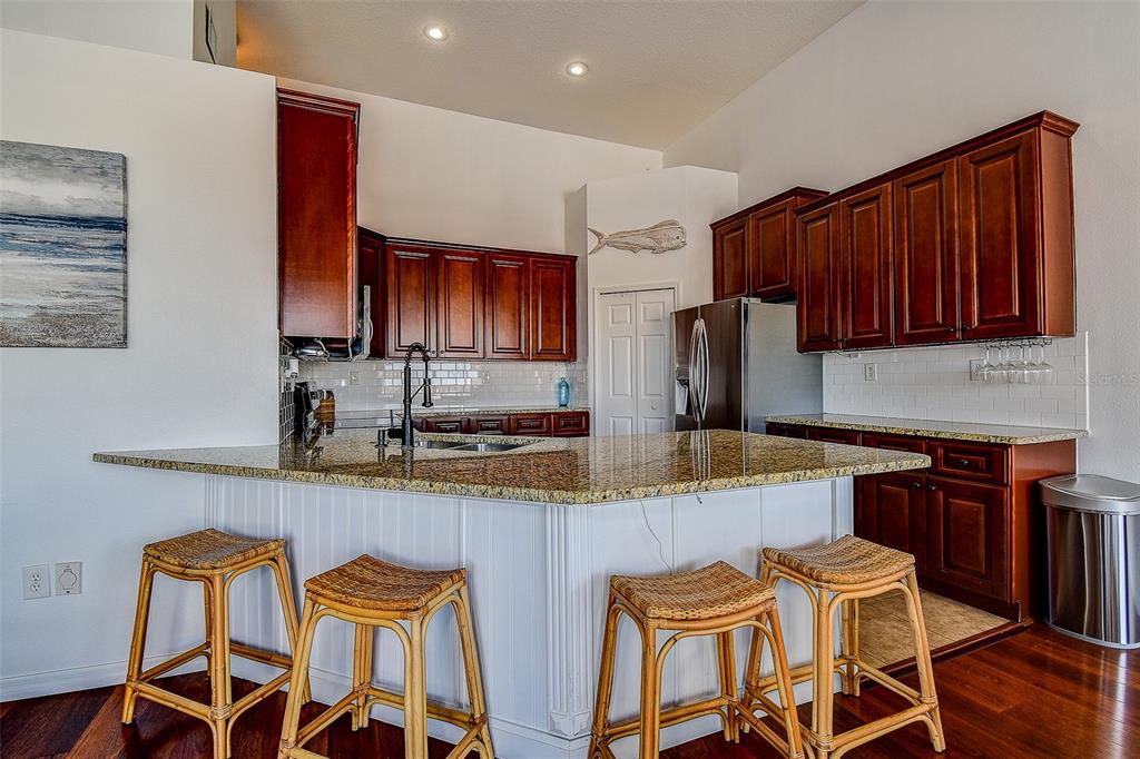 5309 Boardwalk Street Holiday, FL 34690 - Photo 13 of 50 a kitchen with stainless steel appliances granite countertop a table chairs sink and microwave