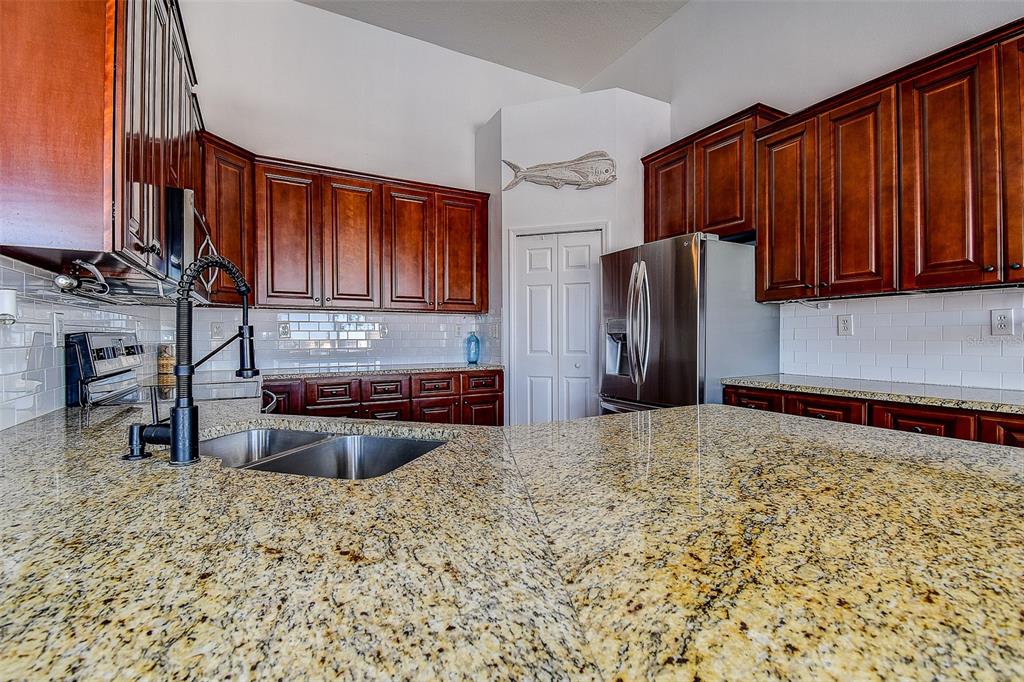 5309 Boardwalk Street Holiday, FL 34690 - Photo 17 of 50 a kitchen with stainless steel appliances granite countertop a refrigerator stove and sink
