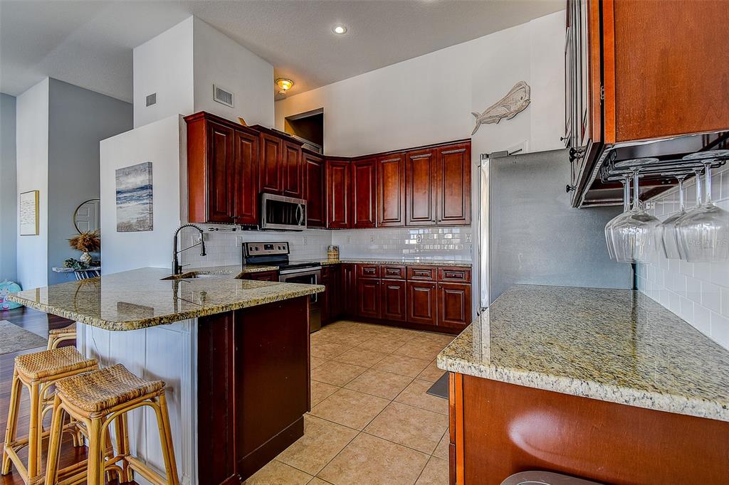 5309 Boardwalk Street Holiday, FL 34690 - Photo 20 of 50 a kitchen with stainless steel appliances granite countertop a sink stove and refrigerator