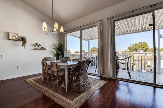 a view of a dining room with furniture a chandelier and wooden floor