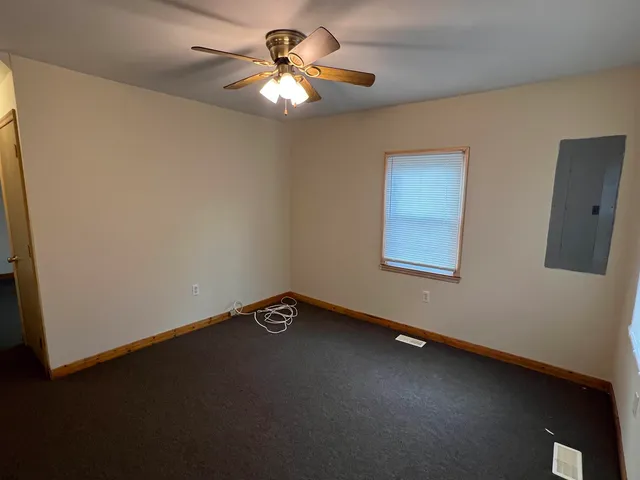 a view of an empty room with a chandelier fan
