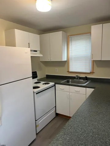 a kitchen with appliances a sink and a refrigerator
