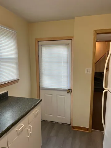 an entryway with wooden floor and cabinet