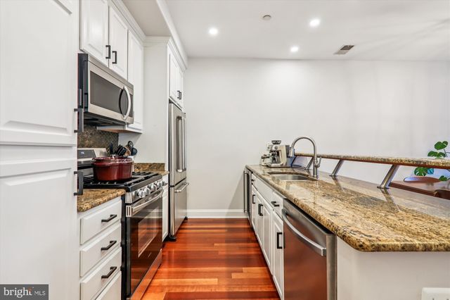 a kitchen with granite countertop a stove and a sink