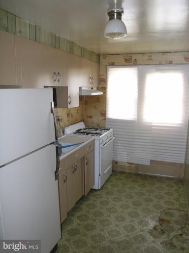 3702 Greenvale Road Baltimore, MD 21229 - Photo 3 of 15 a kitchen with a sink a stove cabinets and a window
