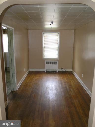 3702 Greenvale Road Baltimore, MD 21229 - Photo 7 of 15 an empty room with wooden floor and windows