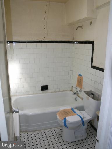 3702 Greenvale Road Baltimore, MD 21229 - Photo 10 of 15 a white toilet sitting next to a bath tub and a shower