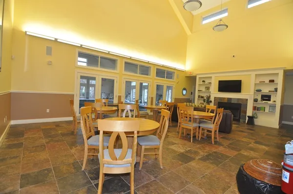 a dining room with furniture a fireplace and a flat screen tv