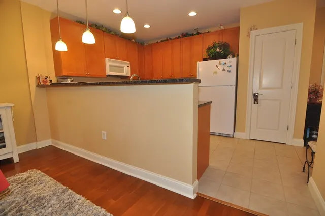 a view of a refrigerator in kitchen and wooden floor