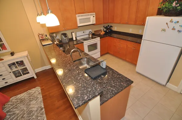 a view of a kitchen with a sink dishwasher stove and refrigerator