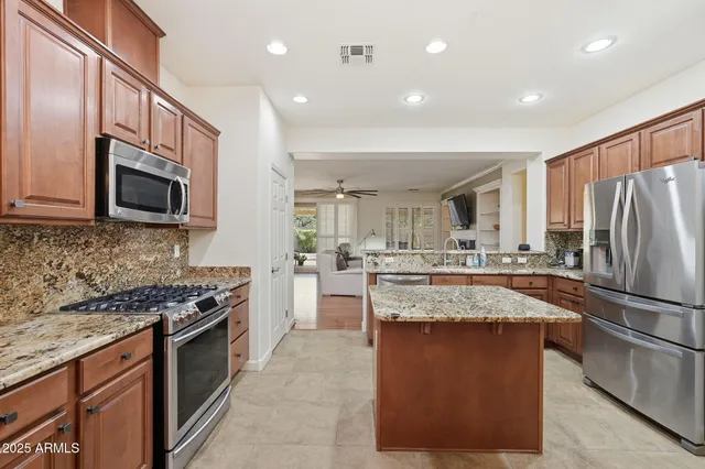 a kitchen with stainless steel appliances granite countertop a refrigerator and a sink
