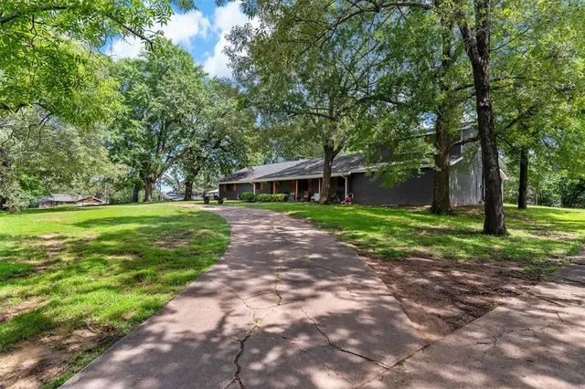 a front view of a house with yard and green space