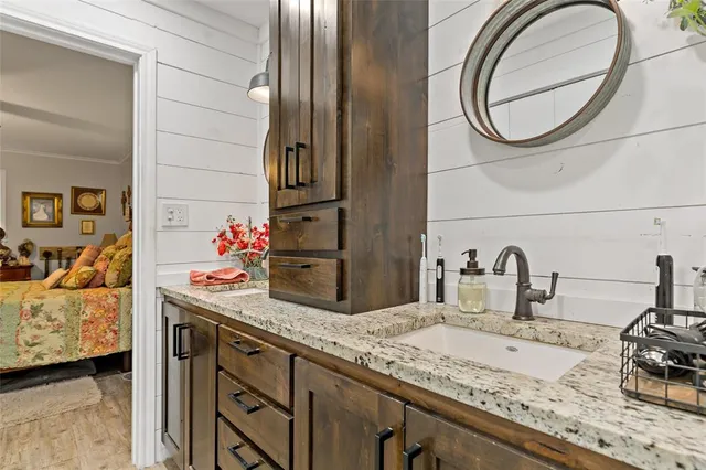 a bathroom with a granite countertop sink and a mirror