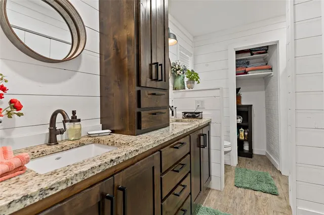 a bathroom with a granite countertop sink and a mirror