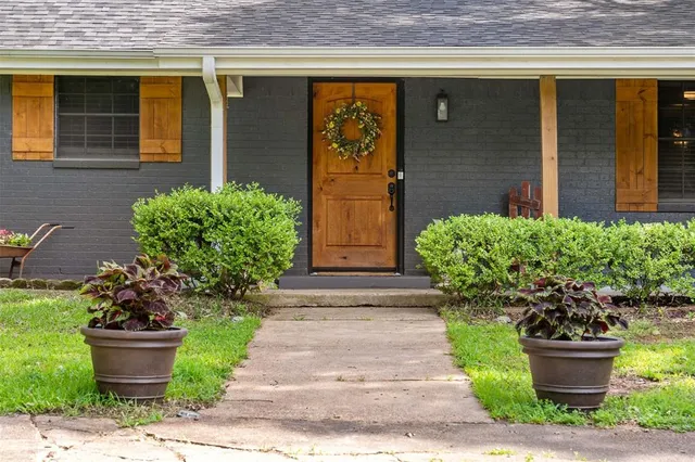 a front view of a house with lots of potted plants