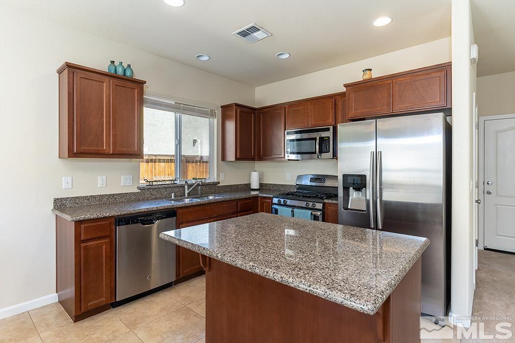 1863 Star Bright Way Reno, NV 89523 - Photo 4 of 22 a kitchen with stainless steel appliances granite countertop a sink a stove and a refrigerator